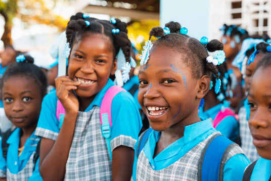 TropiClean by Cosmos Group gives back to community. Image of schoolgirls with backpacks smiling outdoors