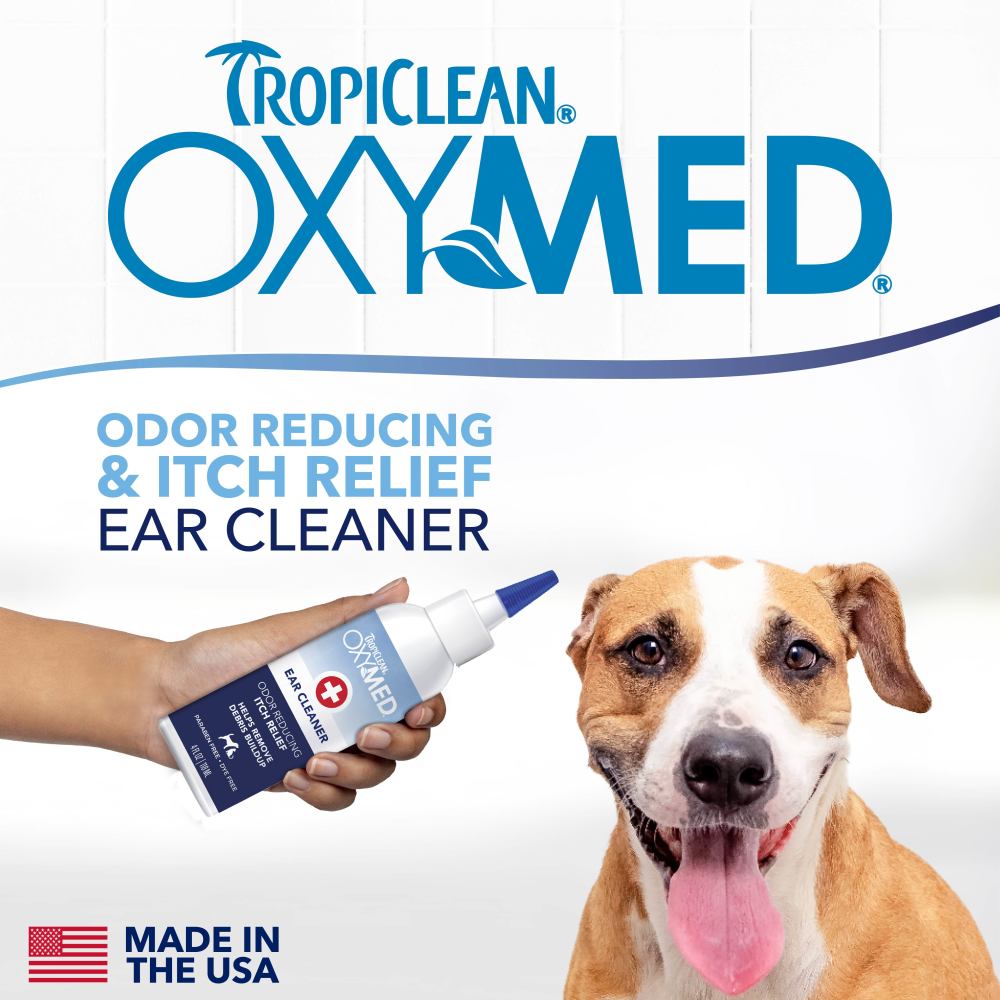 TropiClean OxyMed ear cleaner made in USA with a dog and hand holding the product on a white background