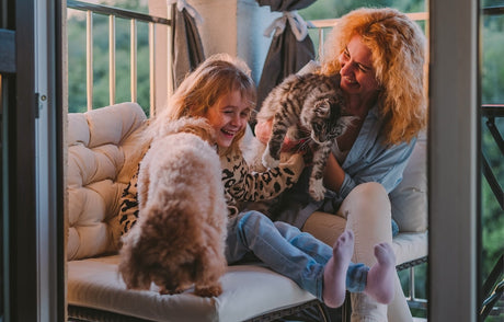 Blog: What Are Naturally Derived Ingredients—and Why It Matters for Your Pet. Woman and child with dog and cat.