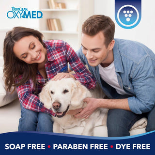 TropiClean OxyMed Ear Cleaner for Dogs and Cats. Couple with a dog on a couch, Tropiclean OxyMed branding visible