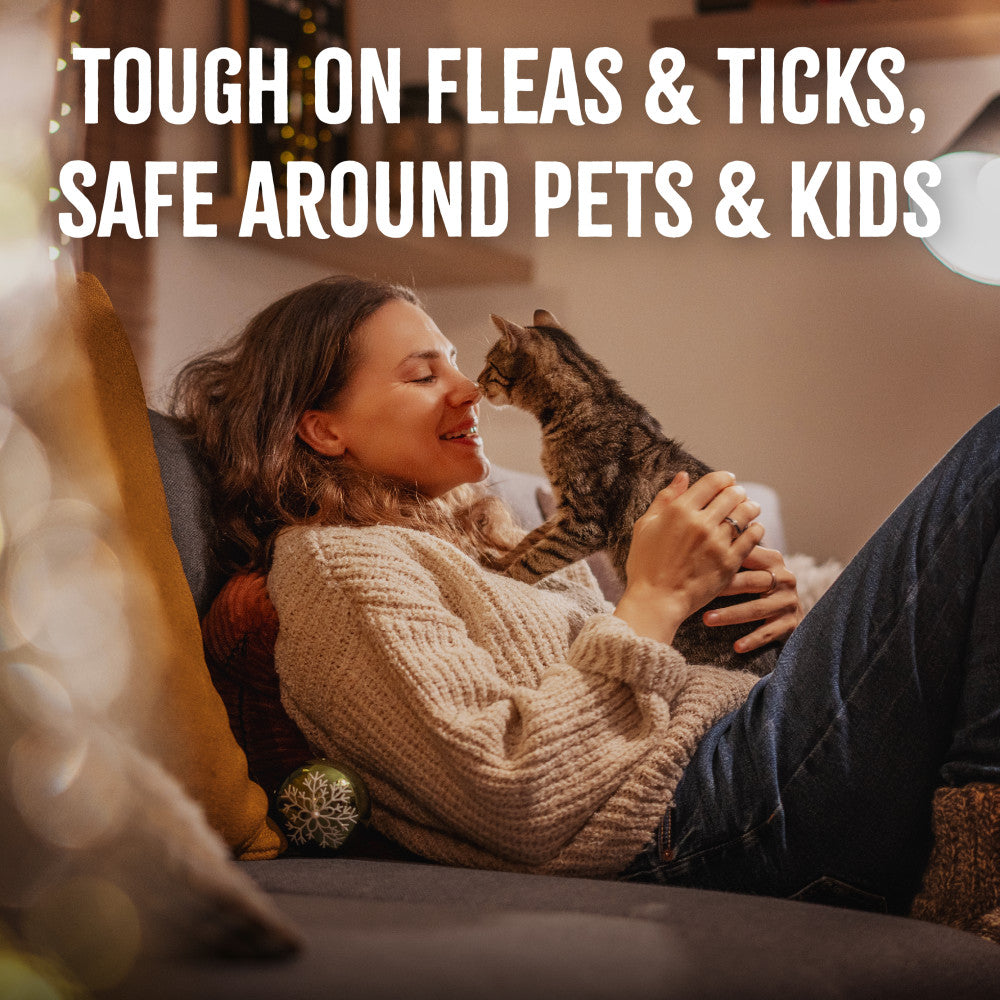 Woman holding a cat on a couch with text about TropiClean Natural Flea + Tick Waterless Shampoo for Cats product features
