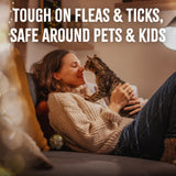 Woman holding a cat on a couch with text about TropiClean Natural Flea + Tick Waterless Shampoo for Cats product features