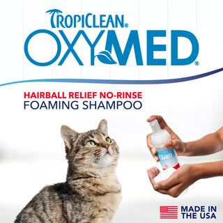 TropiClean OxyMed Waterless Dry Shampoo for Cats, image of cat and a hand with the product