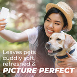 Woman taking a selfie with a dog, surrounded by nature