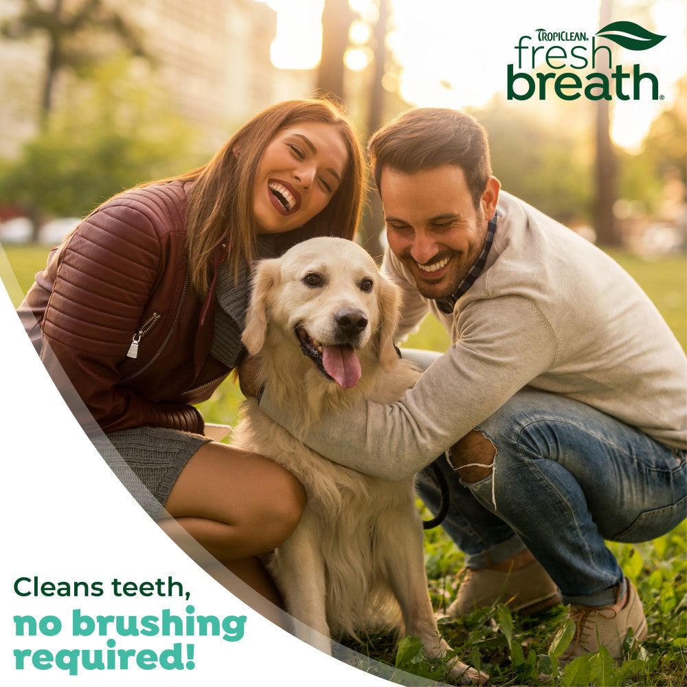 Couple with a dog in a park, promoting 'TropiClean Fresh Breath' products.