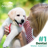 Woman holding a puppy with 'TropiClean fresh breath' branding and text about dental water additive.