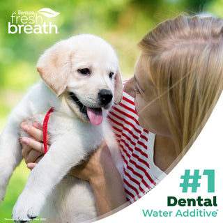 Woman holding a puppy with 'TropiClean fresh breath' branding and text about dental water additive.