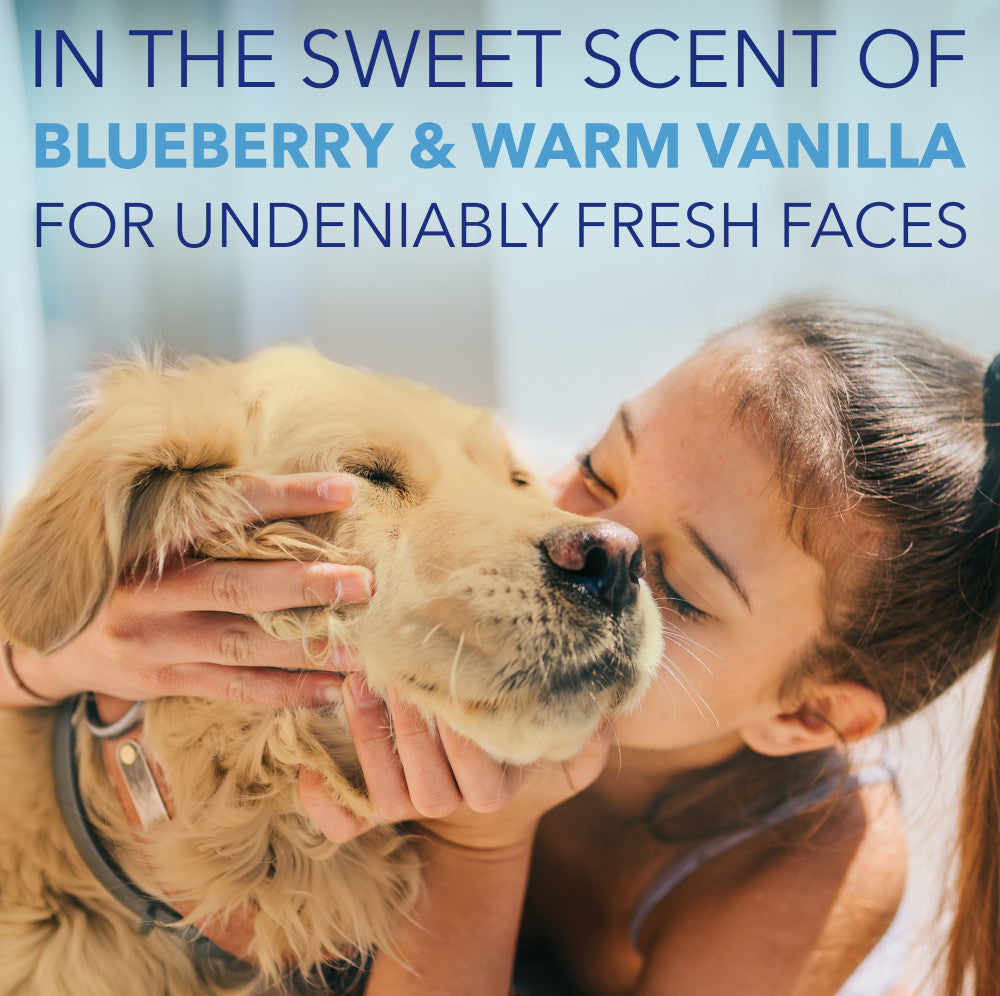 Woman kissing a dog with text about blueberry and warm vanilla scents.