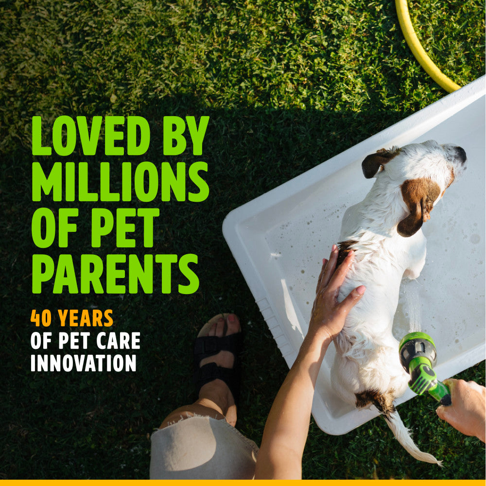 Person washing a dog with text about TropiClean pet care innovation on a grassy background