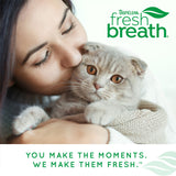 Woman kissing a cat with TropiClean Fresh Breath logo and tagline.